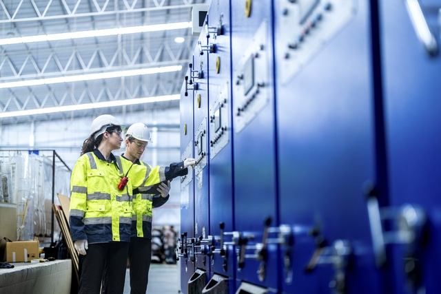 Ingenieros supervisando sistema de almacenamiento energético industrial BESS con cuadros eléctricos y control de potencia