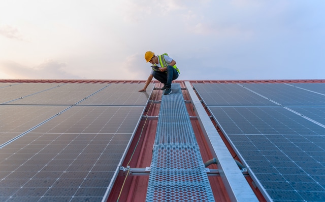Técnico realizando mantenimiento profesional en instalación solar térmica sobre cubierta con acceso técnico seguro